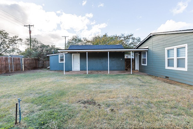 rear view of house featuring a lawn