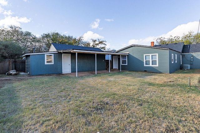 rear view of property featuring a yard and central AC