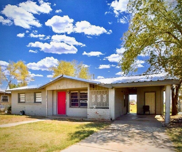 ranch-style home with an attached carport, brick siding, driveway, and a front lawn