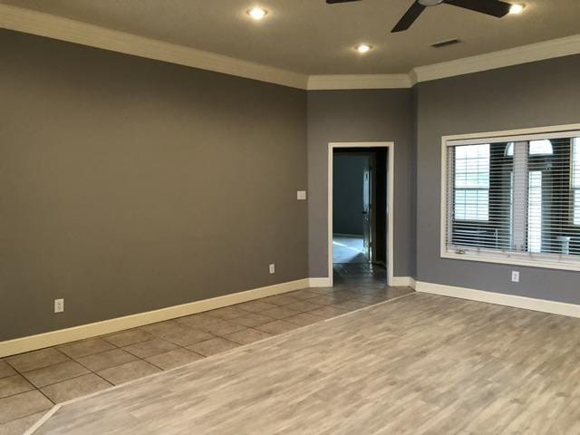 tiled empty room with crown molding and ceiling fan