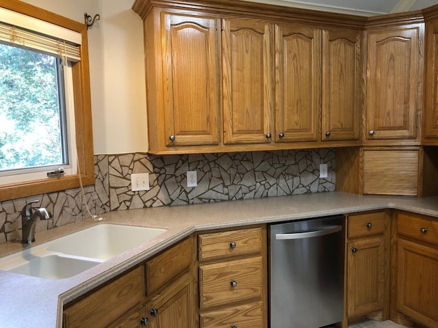 kitchen featuring tasteful backsplash, sink, and stainless steel dishwasher