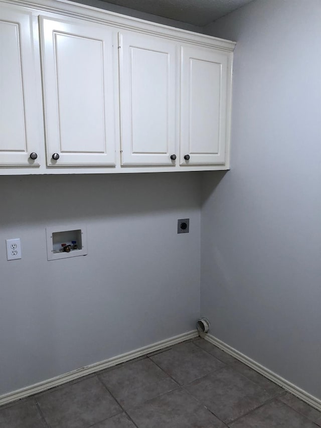 clothes washing area featuring cabinets, dark tile patterned floors, hookup for a washing machine, and electric dryer hookup