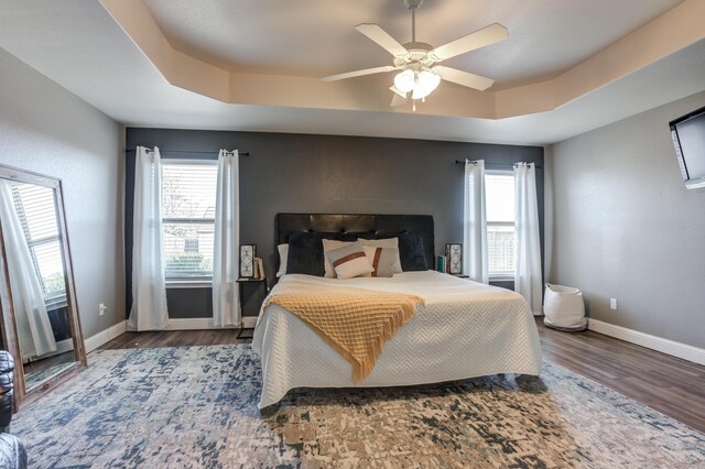 9207 Trenton Ave, Lubbock, TX 79424 - bedroom featuring a raised ceiling, wood finished floors, and a ceiling fan