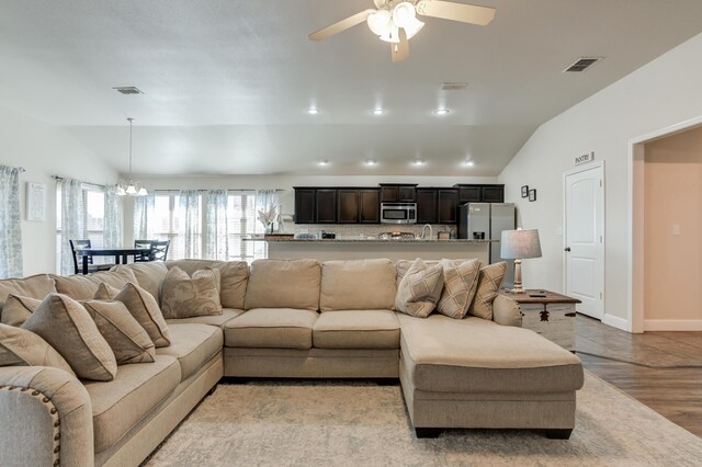9207 Trenton Ave, Lubbock, TX 79424 - living room with lofted ceiling, a ceiling fan, a chandelier, and light wood-style floors