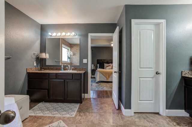 9207 Trenton Ave, Lubbock, TX 79424 - ensuite bathroom with double vanity and baseboards