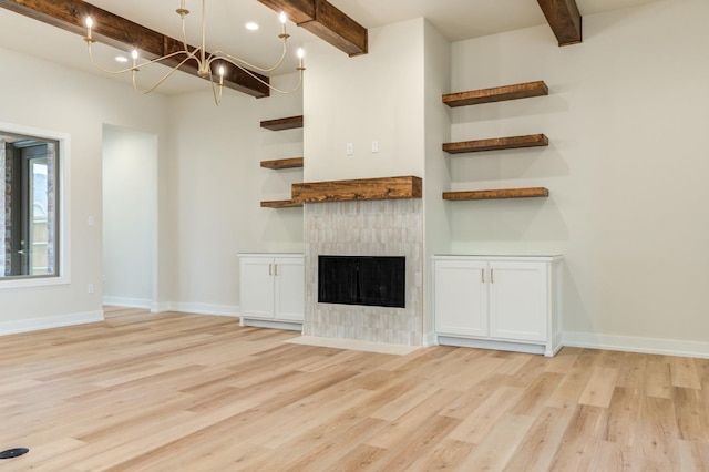 unfurnished living room featuring beam ceiling, a tile fireplace, and light hardwood / wood-style flooring