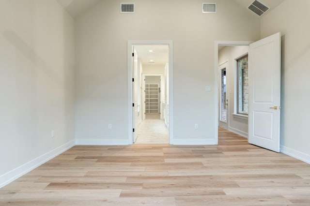 unfurnished bedroom with lofted ceiling and light hardwood / wood-style floors