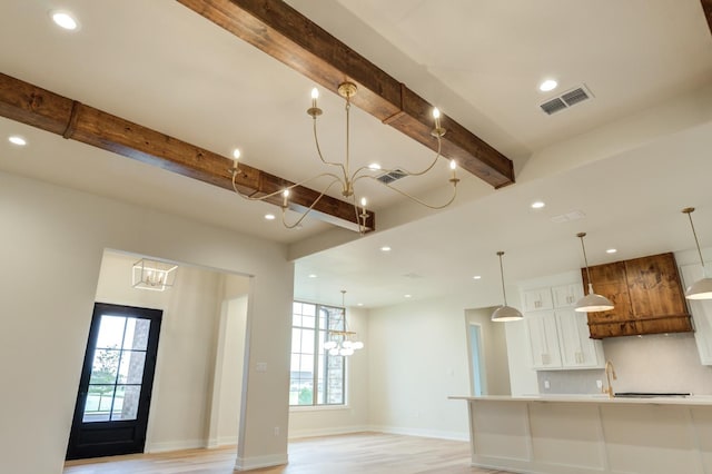 kitchen featuring an inviting chandelier, decorative light fixtures, beamed ceiling, light hardwood / wood-style floors, and white cabinets