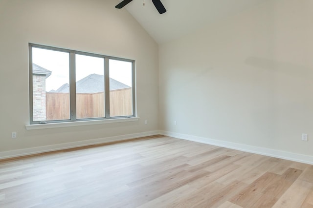 empty room featuring a wealth of natural light, high vaulted ceiling, ceiling fan, and light wood-type flooring