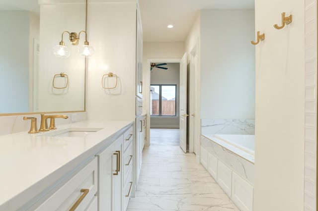 bathroom with vanity, tiled tub, and ceiling fan