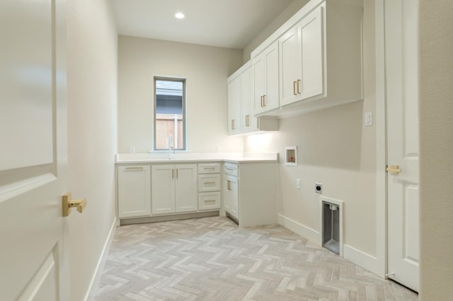 laundry room with sink, light parquet floors, cabinets, washer hookup, and hookup for an electric dryer