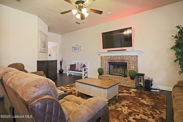 11104 Englewood Ave, Lubbock, TX 79424 - living area featuring visible vents, a fireplace, dark wood-style flooring, a ceiling fan, and baseboards