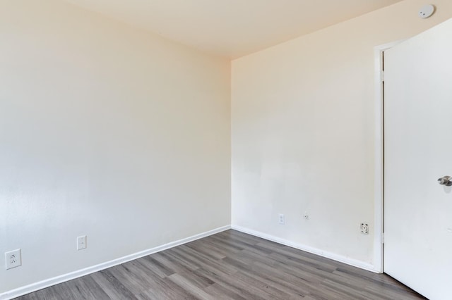 unfurnished room with dark hardwood / wood-style flooring