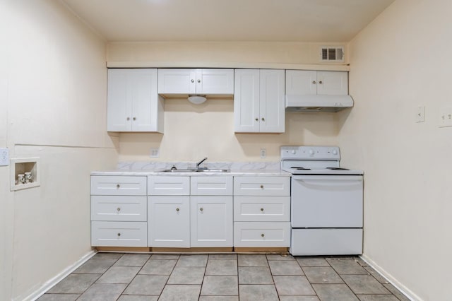 kitchen with light tile patterned flooring, sink, electric range, light stone countertops, and white cabinets