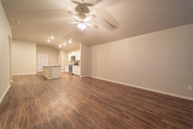 unfurnished living room with ceiling fan, sink, dark hardwood / wood-style floors, and vaulted ceiling