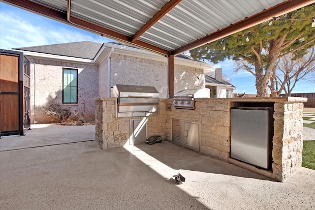 view of patio / terrace featuring an outdoor kitchen and a grill