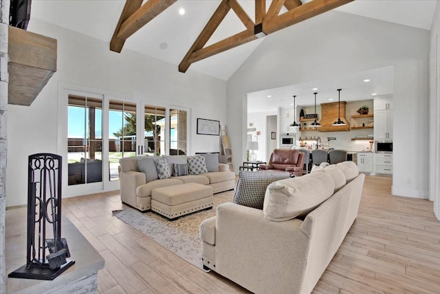 living room featuring high vaulted ceiling, light hardwood / wood-style floors, sink, and beamed ceiling