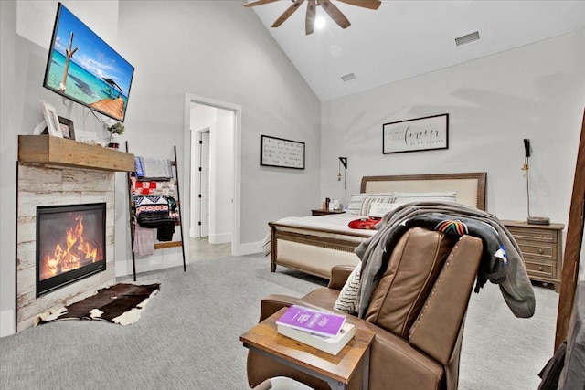 carpeted bedroom with ceiling fan, a fireplace, and high vaulted ceiling