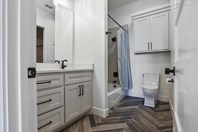 full bathroom featuring parquet flooring, shower / tub combo with curtain, vanity, and toilet