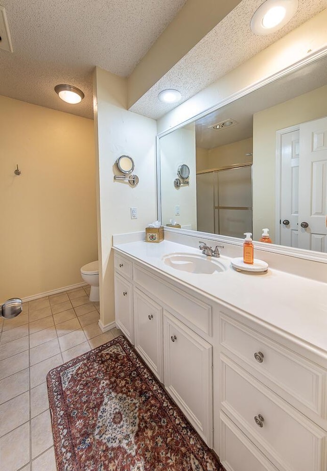 10609 Elkridge Ave, Lubbock, TX 79423 - bathroom with vanity, a textured ceiling, tile patterned floors, and an enclosed shower