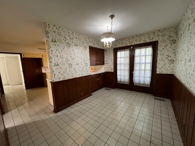 kitchen with an inviting chandelier, light tile patterned floors, and pendant lighting