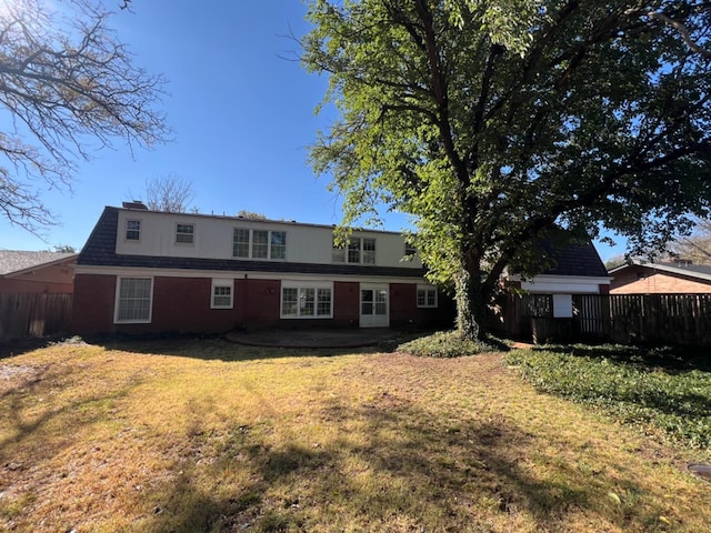 rear view of house featuring a lawn