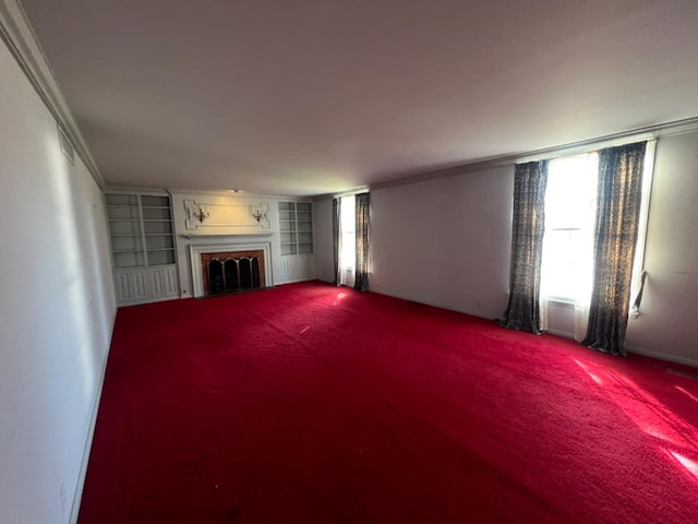 unfurnished living room featuring ornamental molding, a brick fireplace, carpet floors, and built in features