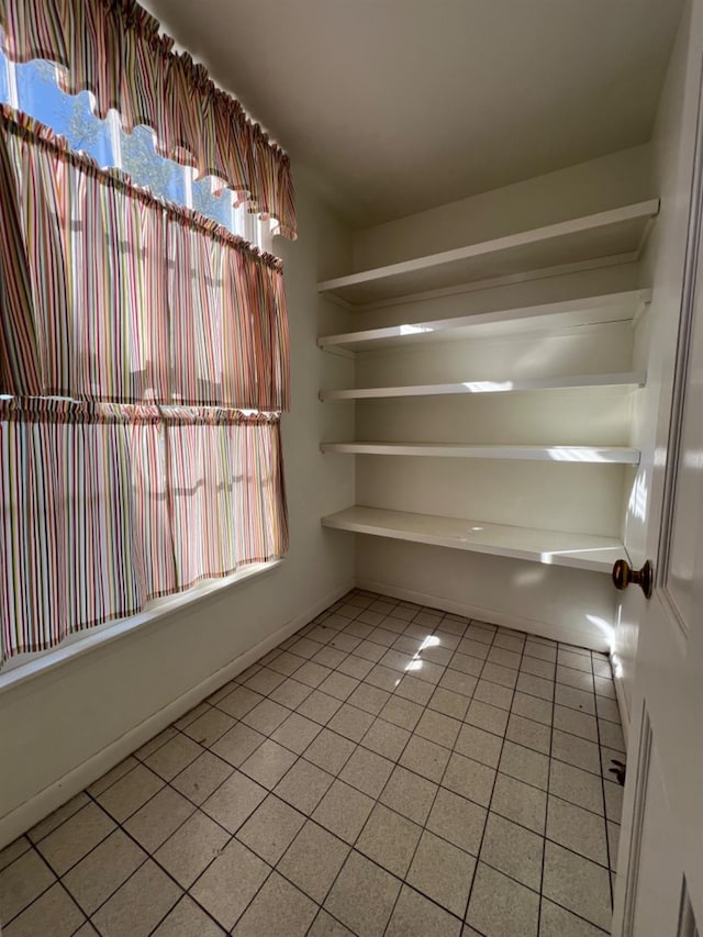 empty room with a healthy amount of sunlight and light tile patterned flooring