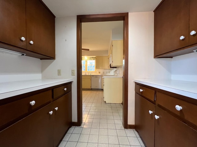 kitchen featuring dishwasher, stove, dark brown cabinets, and light tile patterned flooring