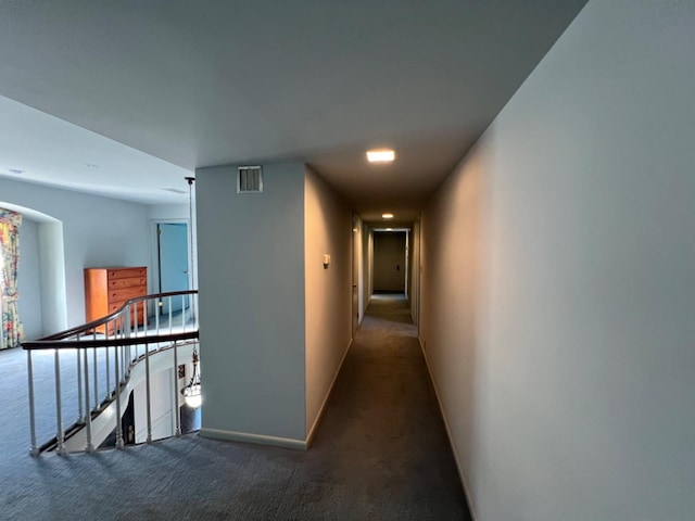 hallway with dark colored carpet