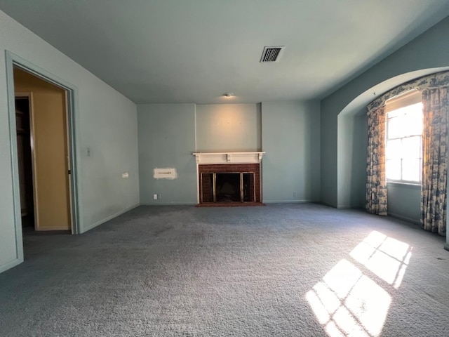 unfurnished living room with carpet floors and a brick fireplace