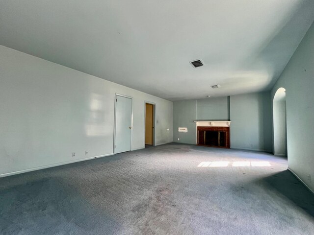 unfurnished living room with carpet floors and a fireplace