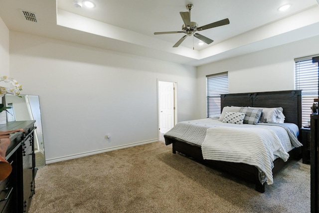 bedroom with carpet floors, a raised ceiling, and ceiling fan