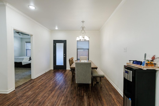 dining room with crown molding, dark hardwood / wood-style floors, a wealth of natural light, and a notable chandelier