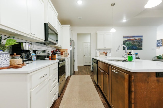 kitchen with sink, decorative light fixtures, an island with sink, stainless steel appliances, and white cabinets