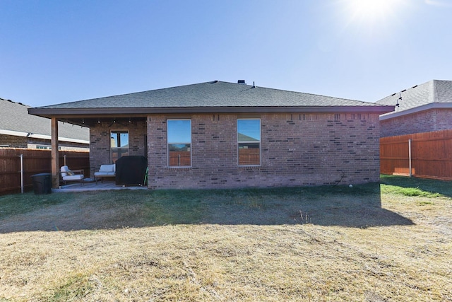 back of house with a yard and a patio