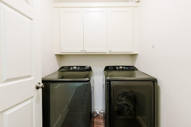 laundry room featuring cabinets, dark hardwood / wood-style floors, and separate washer and dryer