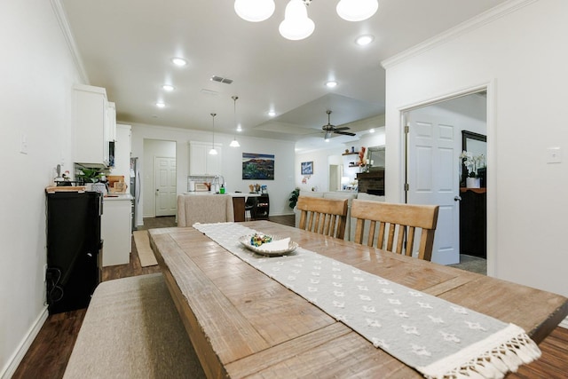 dining area featuring dark wood-type flooring, ornamental molding, and ceiling fan