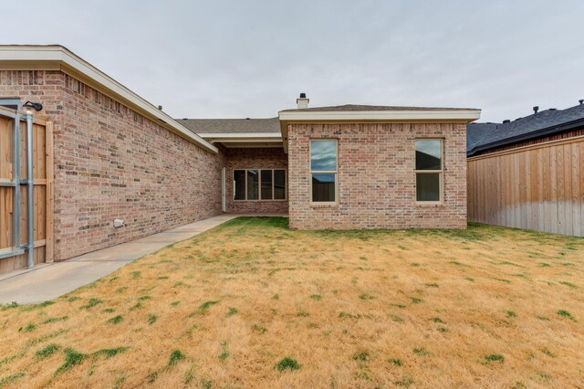 7615 52nd St, Lubbock, TX 79407 - rear view of property featuring brick siding and a chimney