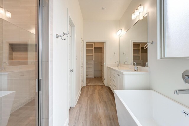 7615 52nd St, Lubbock, TX 79407 - bathroom featuring a walk in closet, a freestanding bath, double vanity, and a shower stall