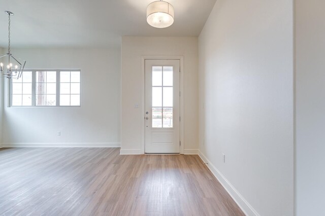 7615 52nd St, Lubbock, TX 79407 - entryway featuring wood finished floors, a chandelier, and baseboards