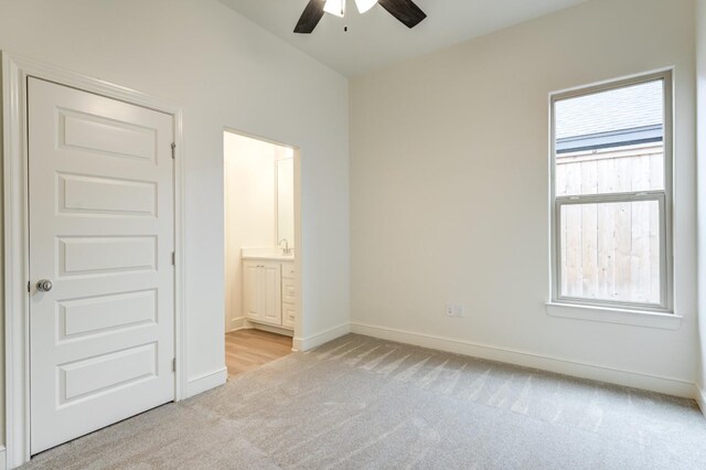 7615 52nd St, Lubbock, TX 79407 - unfurnished bedroom featuring light colored carpet, baseboards, ensuite bath, and a ceiling fan
