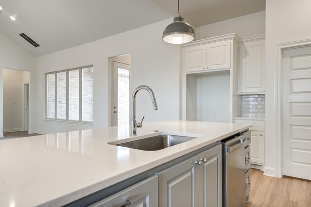 7615 52nd St, Lubbock, TX 79407 - kitchen with a sink, stainless steel dishwasher, light countertops, white cabinetry, and light wood-style floors