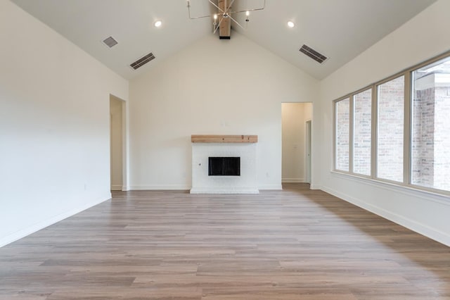 7615 52nd St, Lubbock, TX 79407 - unfurnished living room with a chandelier, high vaulted ceiling, light wood finished floors, baseboards, and a fireplace