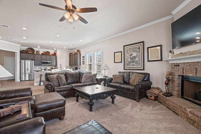 living room with sink, ceiling fan, a fireplace, ornamental molding, and light hardwood / wood-style floors