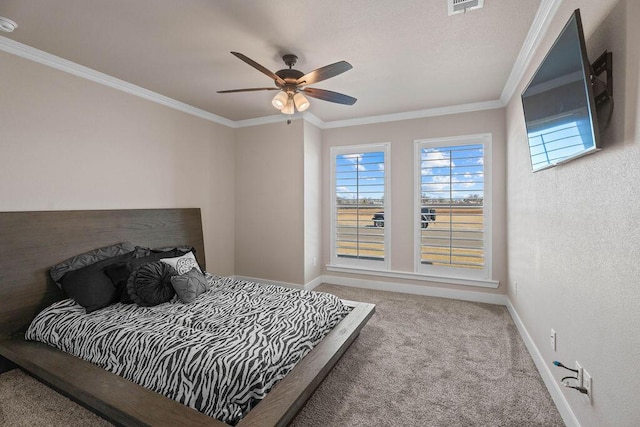 carpeted bedroom with ceiling fan and ornamental molding