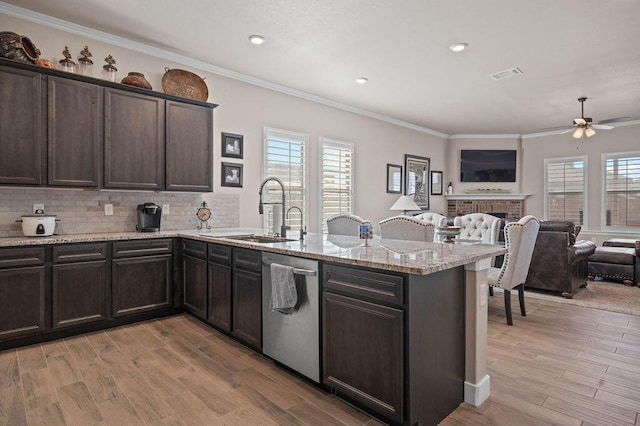 kitchen with sink, light hardwood / wood-style flooring, dishwasher, dark brown cabinets, and ornamental molding