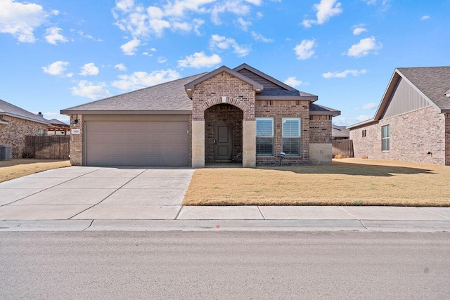 view of front of property featuring a garage, a front lawn, and central air condition unit