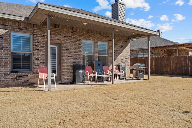 back of house with a yard and a patio area