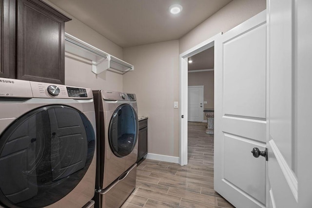 laundry area featuring washer and clothes dryer and cabinets